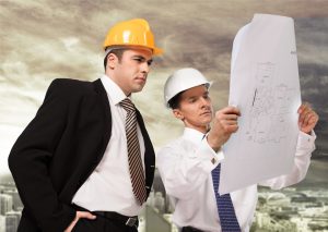 men in ties with hard hats looking at construction plans
